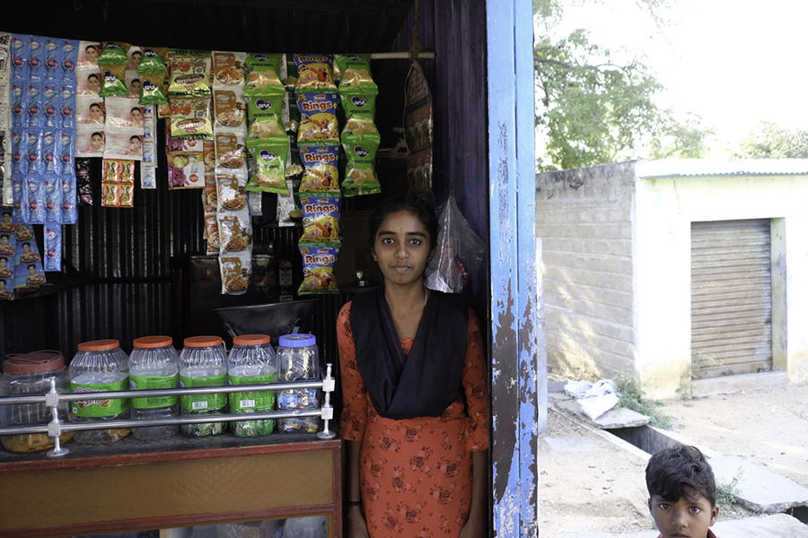 Teenager standing by her family's small shop.