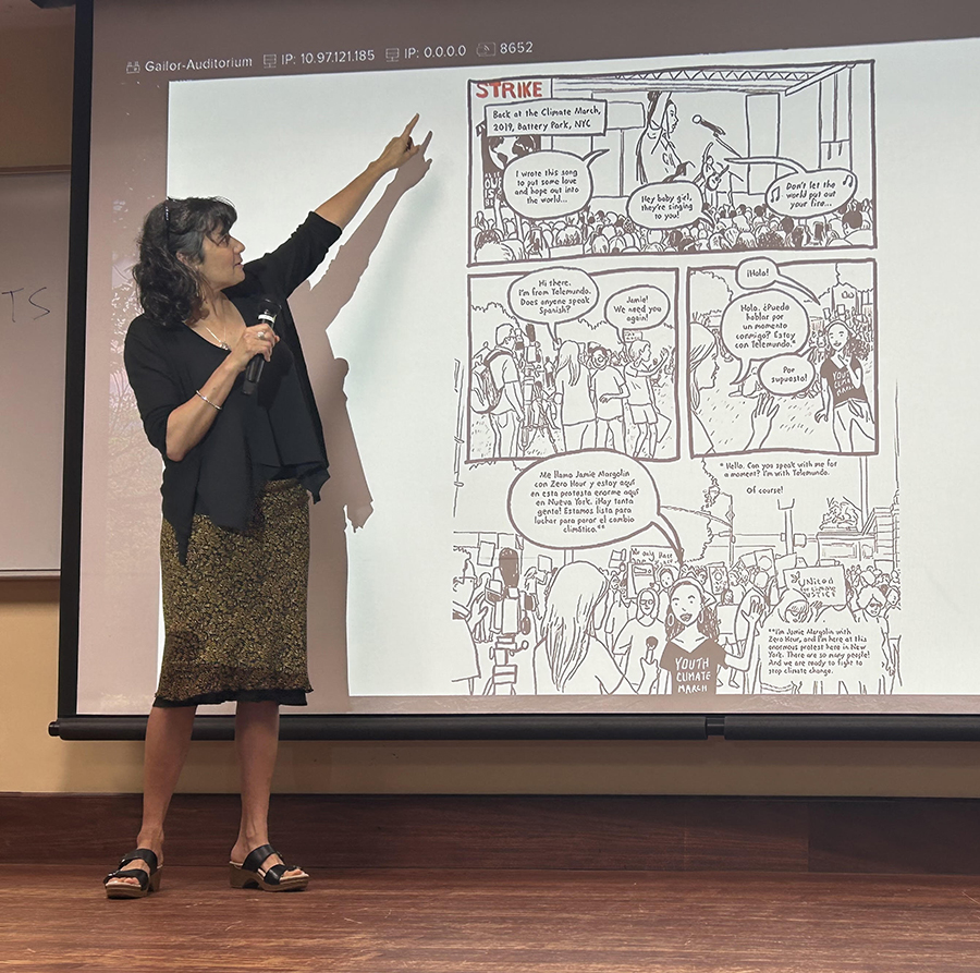 Meera on stage with image from A Better World Is Possible