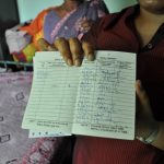 Emily Teresa pulls her LPG gas ration book from its hiding place and points.